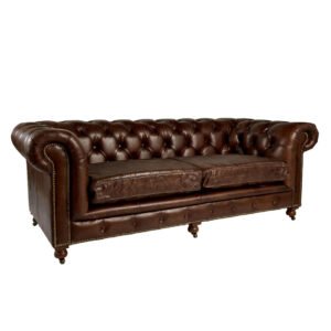 Classic buttoned sofa with brass studs and aged finish – stylish industrial interior